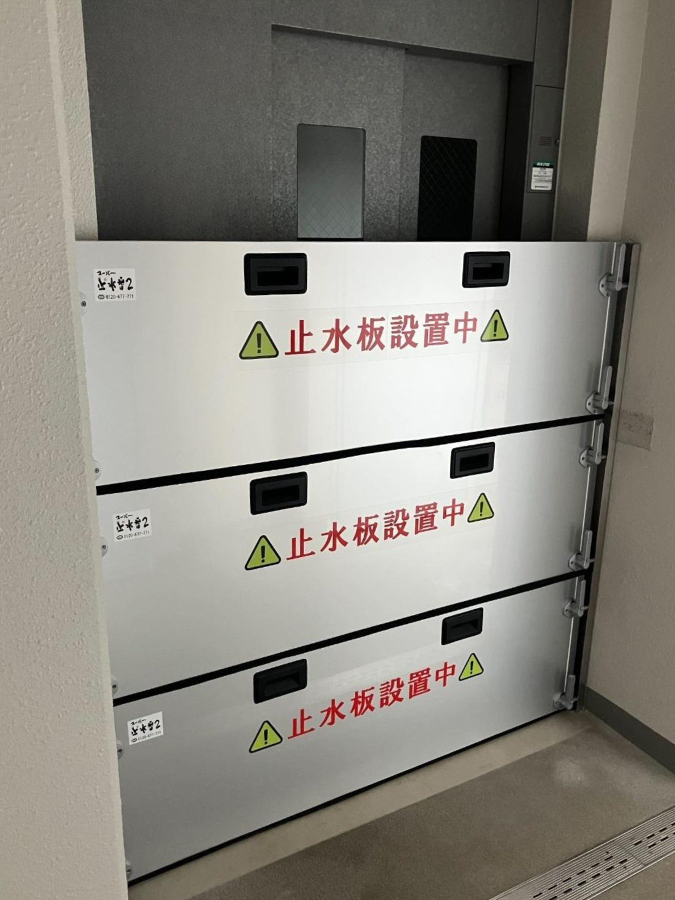 マンションのエレベーター前に三段の防水板支柱タイプ