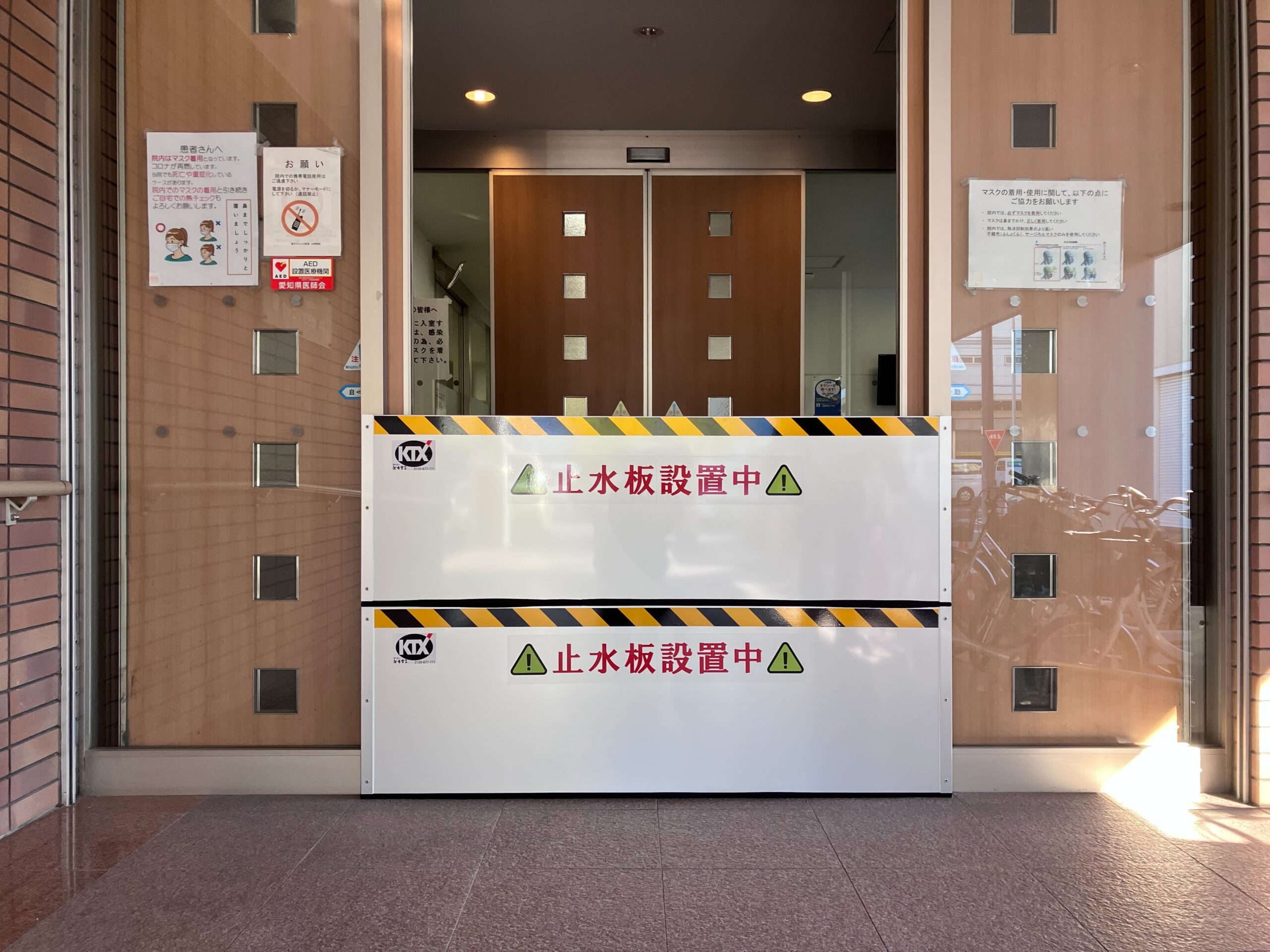 診療所の出入口に収納箱付き防水板マグネットタイプ